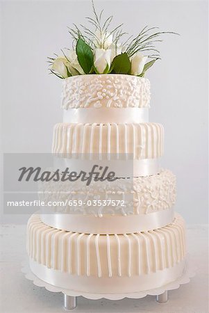 Gâteau de mariage blanc à quatre niveaux avec décoration florale