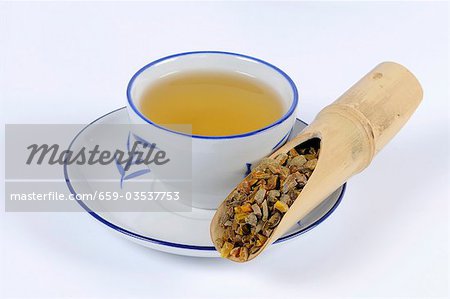 Racine de curcuma avec une tasse de thé