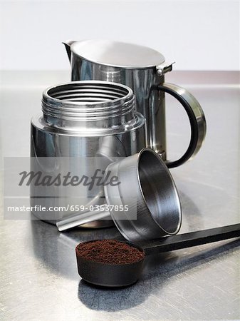 Machine à espresso et cuillère pleine de café moulu