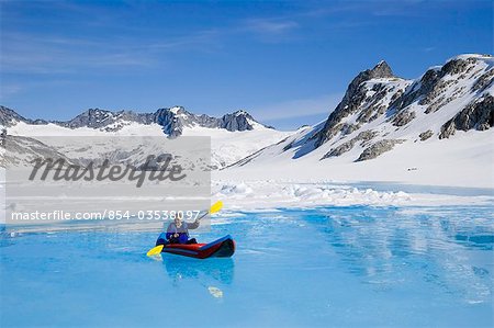 Man kayaking in melt pond on Juneau Ice Field Inside Passage Tongass National Forest southeast Alaska summer