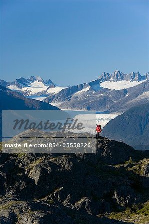 Man hiking in Alaska's Tongass National Forest with view of Mendenhall Glacier near Juneau Alaska southeast Autumn