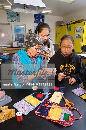 Aîné Yupik native femme enseigne les jeunes à du bourrelet travaille @ Akiak High School, à l'intérieur de l'ouest de l'Alaska