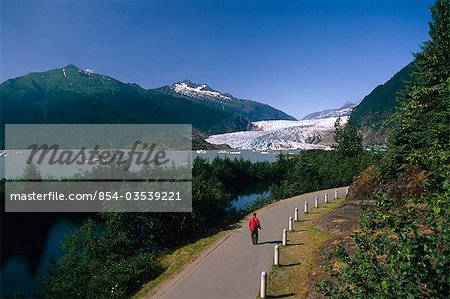 Visitor walking on trail system around Mendenhall Lake w/Glacier Coast Mtns Tongass National Forest AK