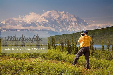 Male tourist views Mt.McKinley & Alaska Range near Wonder Lake Denali National Park Alaska Summer