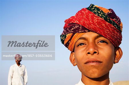 Boy with young man standing in the background, Jaisalmer, Rajasthan, India