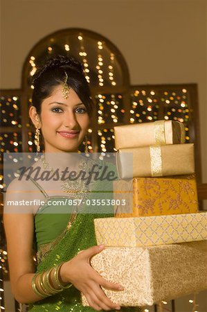 Woman holding Diwali gifts and smiling