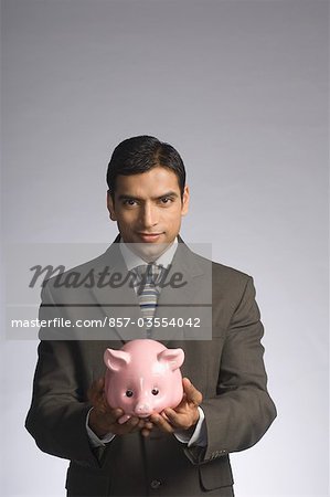 Portrait of a businessman holding a piggy bank