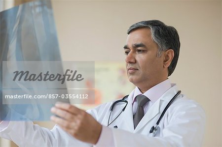 Médecin examinant un rapport aux rayons x, Gurgaon, Haryana, Inde