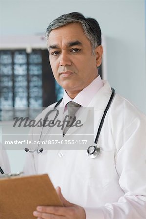 Portrait d'un médecin détenant un presse-papiers, Gurgaon, Haryana, Inde