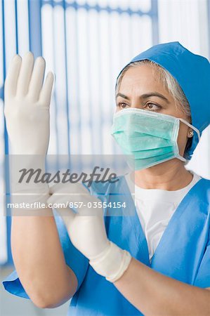 Femme chirurgien chausser des gants chirurgicaux, Gurgaon, Haryana, Inde