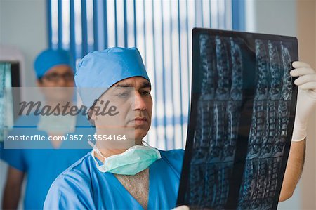 Chirurgien d'examiner un rapport de rayons x, Gurgaon, Haryana, Inde