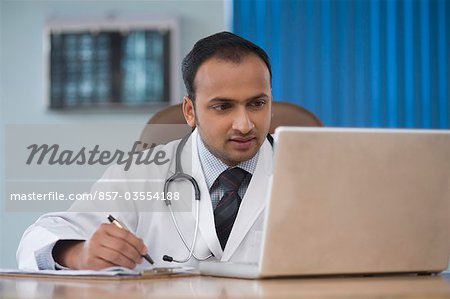 Arzt arbeitet an einem Laptop in einem Krankenhaus, Gurgaon, Haryana, Indien