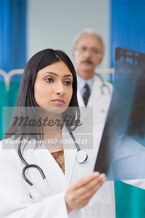 Femme médecin examinant un rapport aux rayons x, Gurgaon, Haryana, Inde