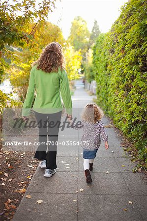 Mutter und Tochter gehen auf Bürgersteig im Herbst, Seattle, Washington, USA