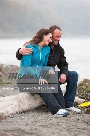 Couple Sittingon Log at Puget Sound in Discovery Park, Seattle, Washington, USA
