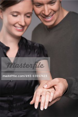 Couple regardant la bague de fiançailles sur des mains de femme