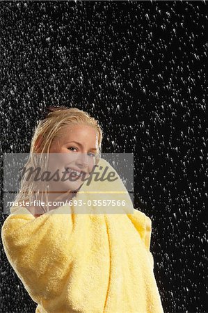 Femme souriante serviette debout sous la pluie