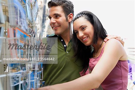 Jeune couple à la recherche de cartes postales, portrait