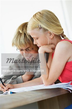 Brother and Sister Doing Homework at table in home