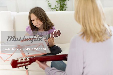 Fillette avec une leçon sur la guitare