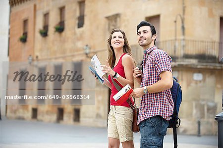 Couple with guidebooks in city square Couple with guidebooks in city square