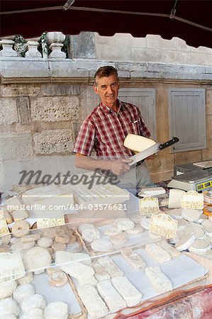 Man at sheeps cheese market stall in france