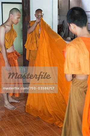 Junge Mönche putzt neue Novize bei Feuerbestattung buddhistische Zeremonie im Wat Luang, Ubon Ratchatani, Thailand