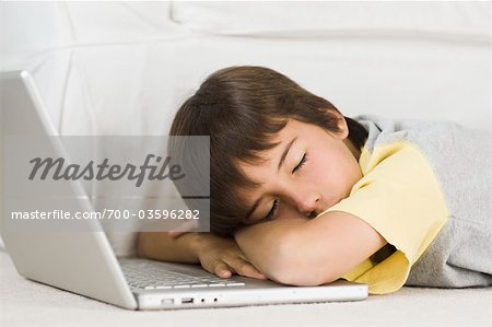 Boy Sleeping on Laptop Computer