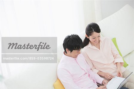 Japanese Couple Relaxing On Sofa