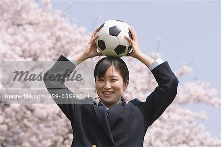 Écolière avec ballon sur la tête