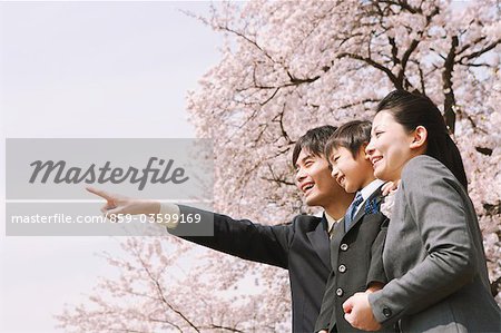 Garçon debout avec les Parents dans le parc