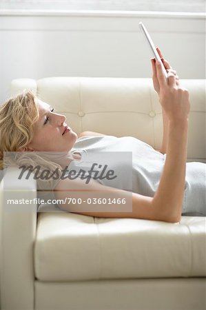 Femme couchée vers le bas en utilisant iPad
