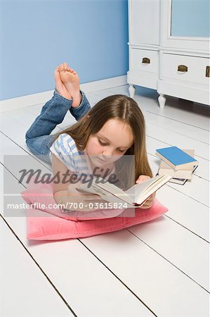 Girl Lying on Floor Reading Book