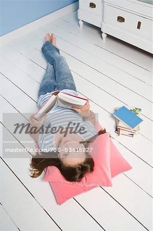 Jeune fille allongée sur le sol et la lecture de livre