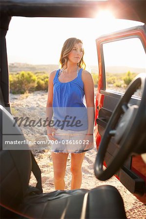 Femme debout par 4x4 véhicule dans le désert au coucher du soleil, près de Cabo Pulmo, Baja California Sur, Mexique