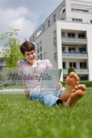 Young woman using iPad in grass