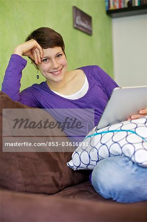 Young woman using iPad on couch