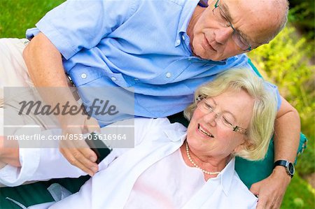 Happy senior couple with smartphone in garden