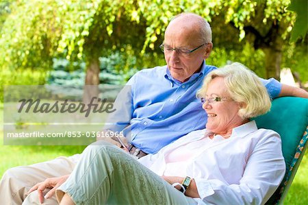 Heureux couple senior avec smartphone dans le jardin