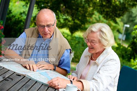 Altes Paar auf der Terrasse mit Blick in den Fahrplan