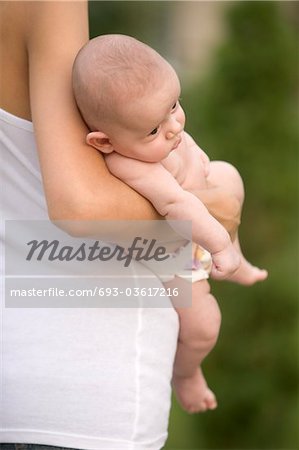 Mother stands holding 2 month old infant son