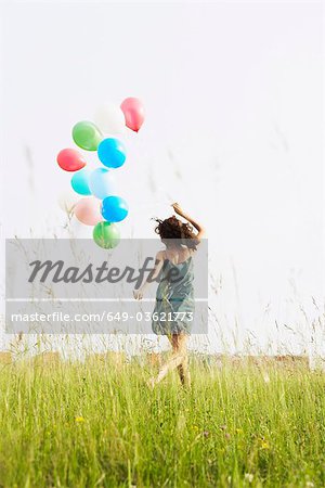 Woman with balloons running away