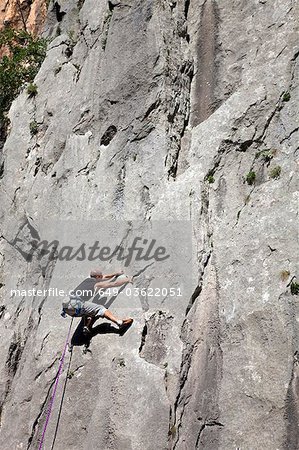 Rock climber climbing rock face