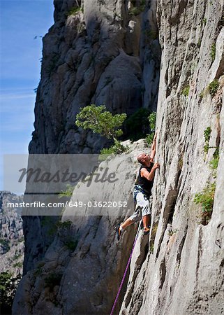 Rock climber climbing rock face