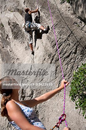 Rock climber securing partner