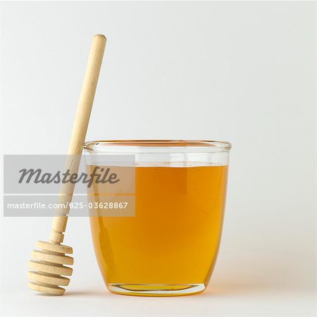 Pot of honey and wooden honey spoon