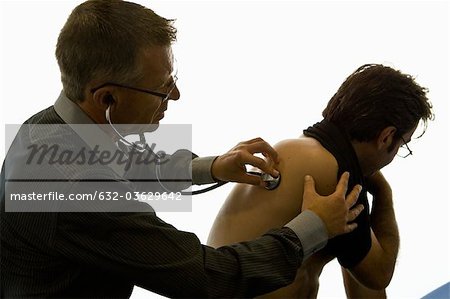 Doctor listening to patient's back with stethoscope
