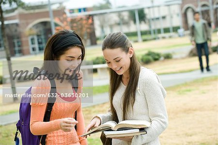 Amis de lycée en regardant livre ensemble