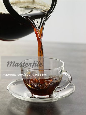 Coffee being Poured into Glass Cup and Saucer Coffee being Poured into Glass Cup and Saucer