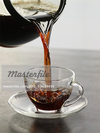 Coffee being Poured into Glass Cup and Saucer